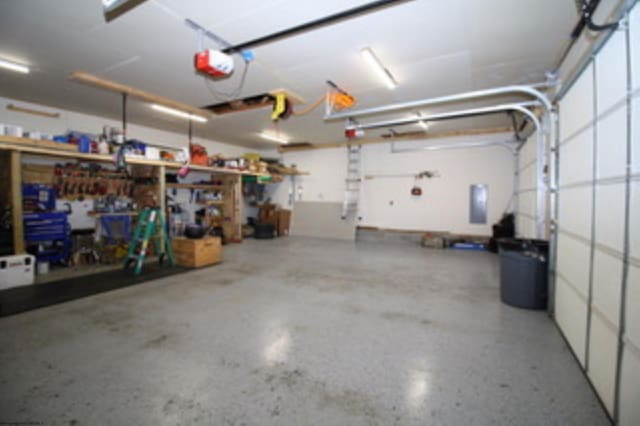 garage with a workshop area and a garage door opener