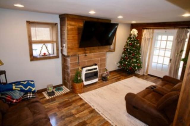 living room with hardwood / wood-style floors, a healthy amount of sunlight, and heating unit