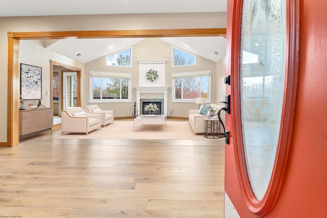 living room featuring a wealth of natural light, lofted ceiling, and light wood-type flooring