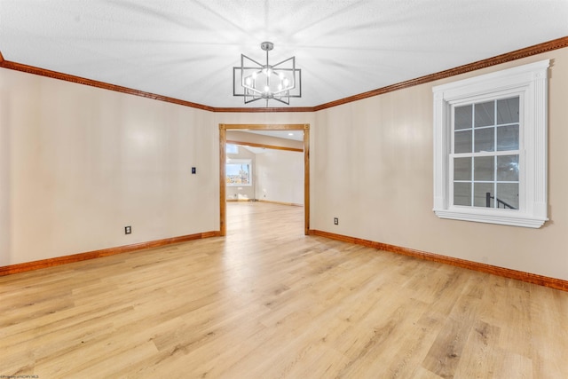 unfurnished room with a textured ceiling, light hardwood / wood-style floors, an inviting chandelier, and ornamental molding