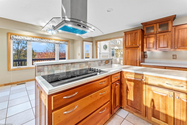 kitchen with decorative backsplash, light tile patterned floors, black electric cooktop, and island range hood