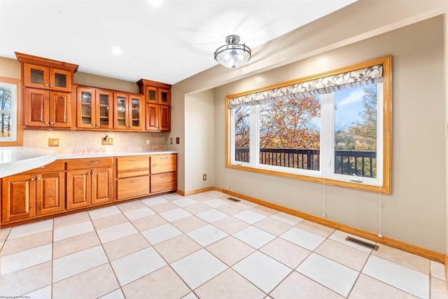 kitchen featuring light tile patterned floors and backsplash