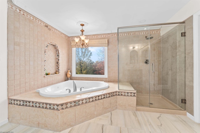 bathroom with shower with separate bathtub and an inviting chandelier