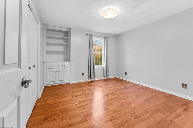 unfurnished bedroom featuring light wood-type flooring and a textured ceiling