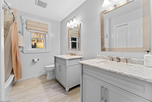 full bathroom featuring wood-type flooring, vanity, toilet, and shower / bath combo with shower curtain