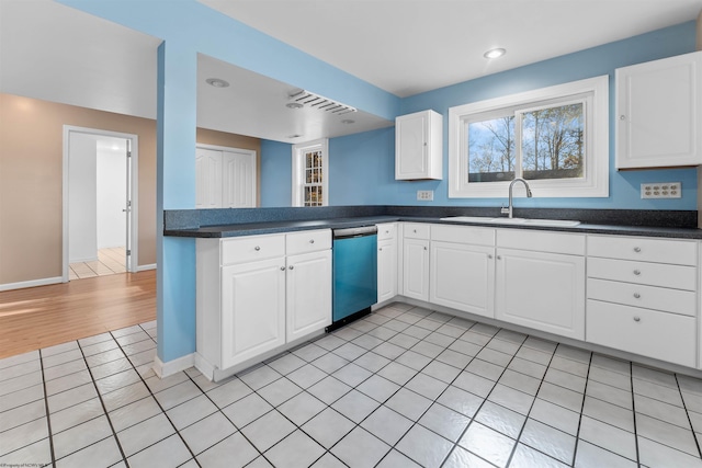 kitchen featuring sink, light hardwood / wood-style flooring, stainless steel dishwasher, white cabinetry, and kitchen peninsula