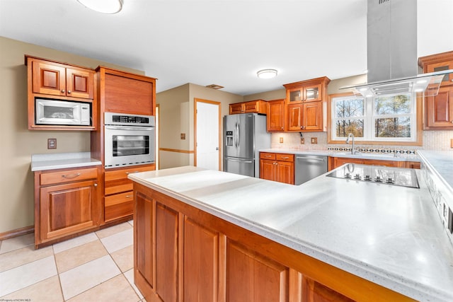 kitchen featuring light tile patterned flooring, backsplash, sink, island range hood, and stainless steel appliances