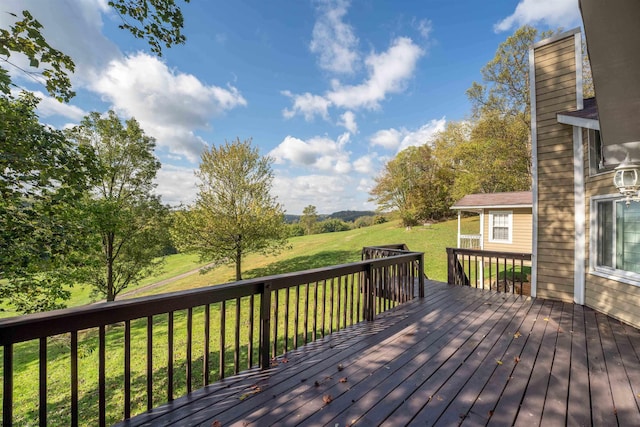 wooden deck featuring a lawn