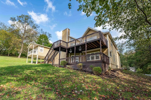 rear view of property featuring a lawn and a wooden deck