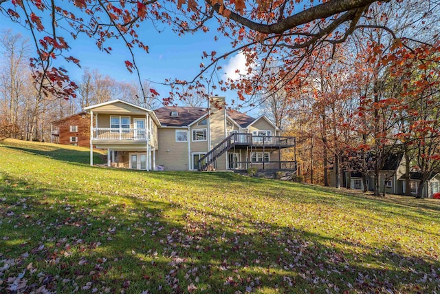 rear view of house featuring a yard and a deck