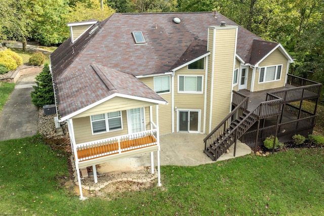 rear view of house featuring cooling unit, a yard, and a wooden deck