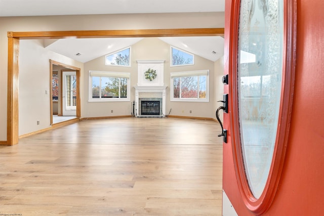 unfurnished living room with light hardwood / wood-style flooring and lofted ceiling