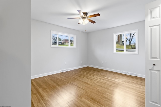 spare room with light hardwood / wood-style floors, ceiling fan, and a healthy amount of sunlight