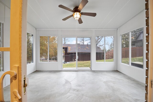 unfurnished sunroom featuring a wealth of natural light and ceiling fan