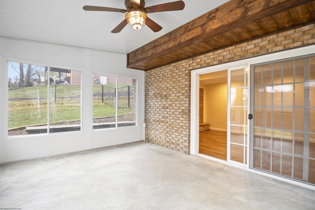 unfurnished sunroom featuring ceiling fan and beamed ceiling