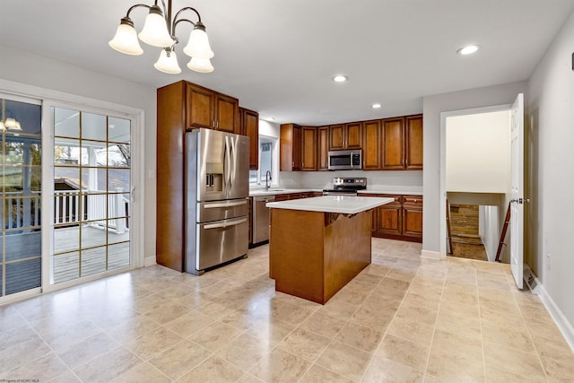 kitchen featuring stainless steel appliances, pendant lighting, a chandelier, a center island, and a breakfast bar area