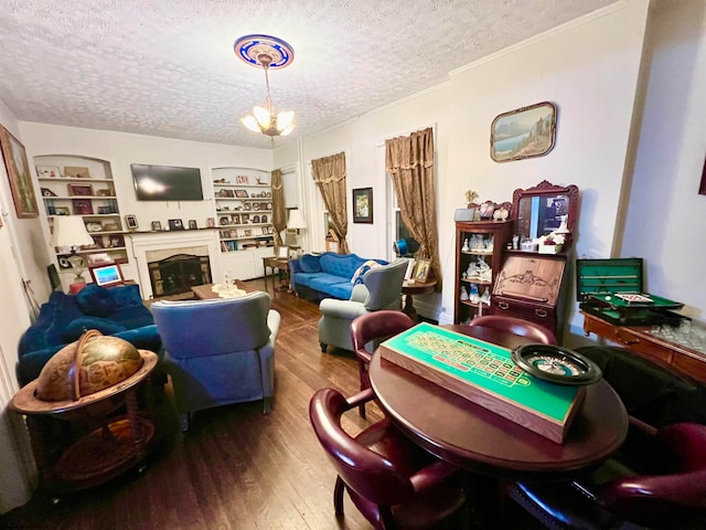 recreation room featuring a chandelier, wood-type flooring, and a textured ceiling