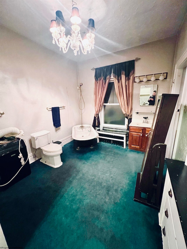 bathroom with vanity, toilet, and a notable chandelier