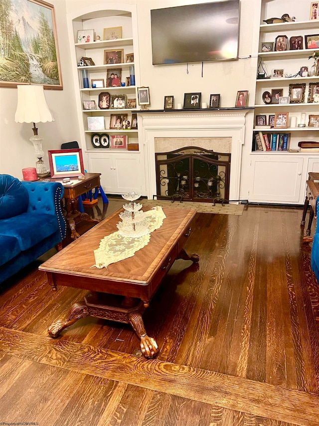 living room with hardwood / wood-style floors and built in features