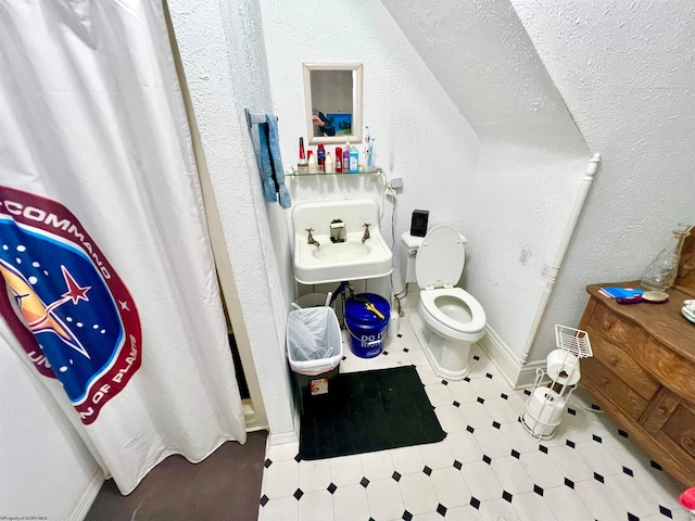 bathroom with a shower with shower curtain, toilet, and sink