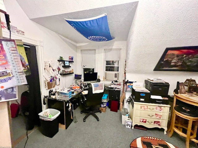 carpeted home office featuring a textured ceiling