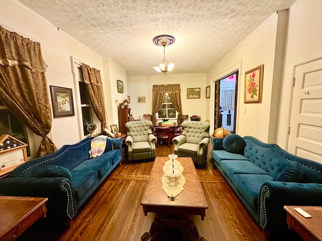 living room with dark wood-type flooring, a textured ceiling, and an inviting chandelier