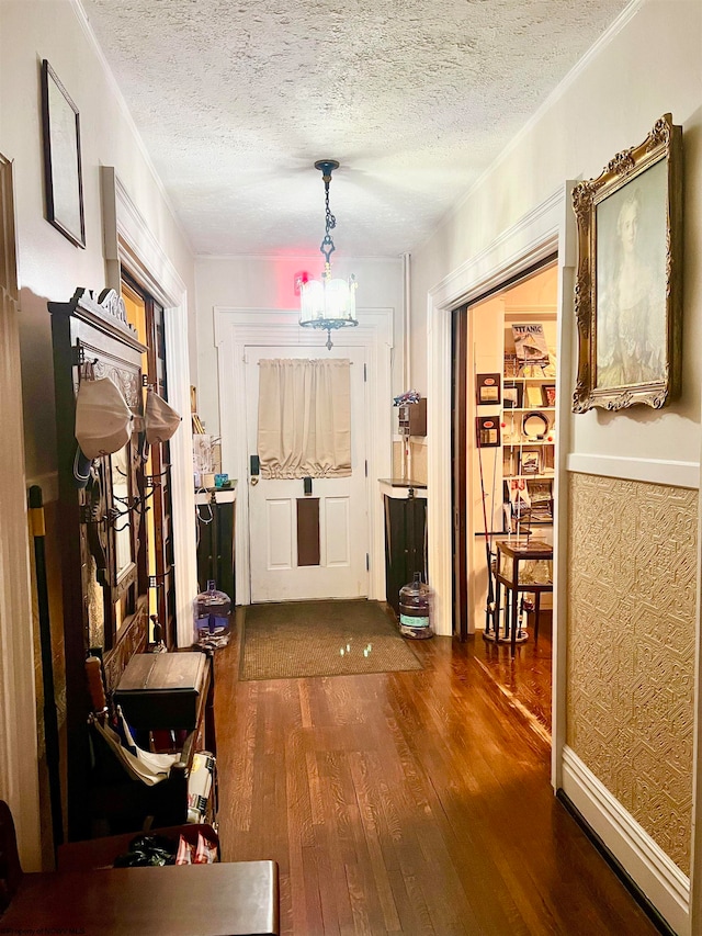 corridor featuring a chandelier, dark wood-type flooring, and a textured ceiling