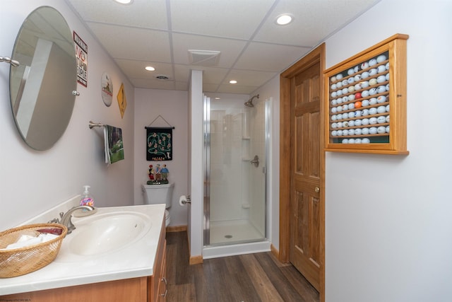 bathroom with hardwood / wood-style floors, vanity, a shower with door, and toilet