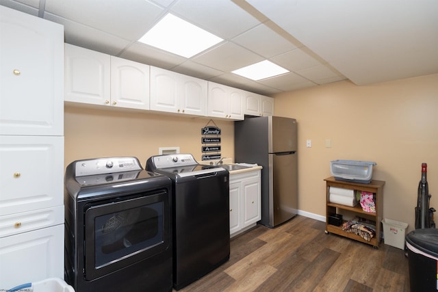 washroom with cabinets, dark wood-type flooring, and washer and dryer