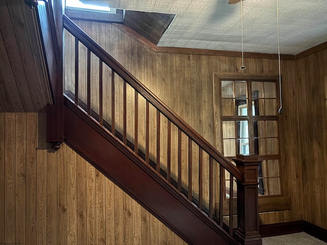 stairway featuring wooden walls