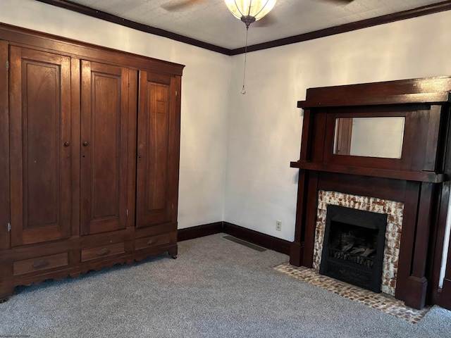 unfurnished living room featuring light carpet, ornamental molding, ceiling fan, and a fireplace