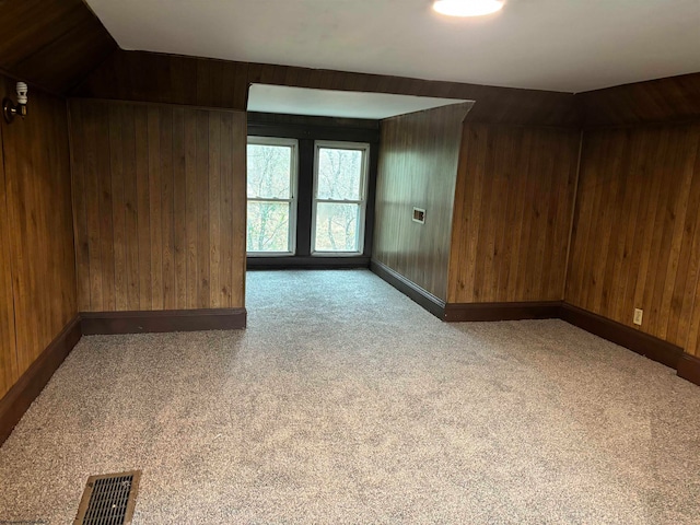 interior space featuring carpet flooring and wooden walls