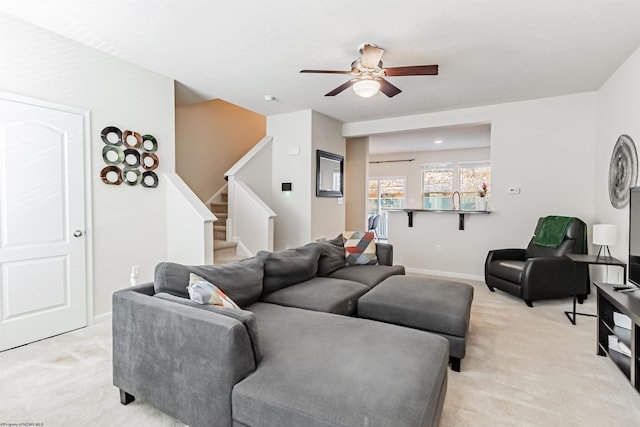 living room featuring light carpet and ceiling fan