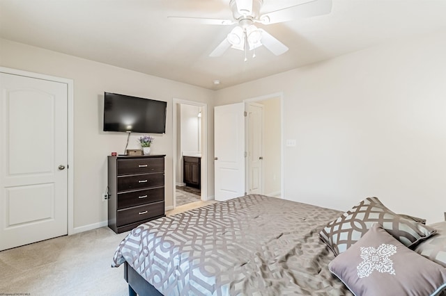 bedroom featuring ceiling fan, light carpet, and connected bathroom