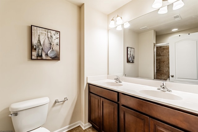 bathroom featuring a shower with door, vanity, and toilet