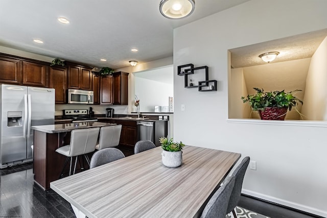 dining area featuring sink and dark wood-type flooring