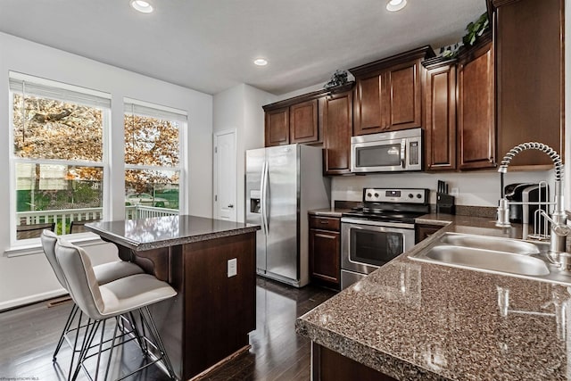 kitchen featuring stainless steel appliances, a kitchen island, dark hardwood / wood-style floors, and sink