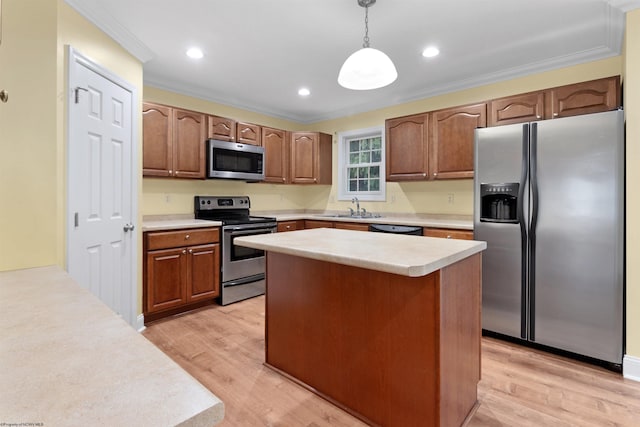 kitchen featuring sink, hanging light fixtures, stainless steel appliances, and light wood-type flooring