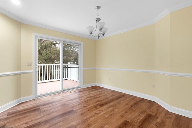 unfurnished dining area featuring wood-type flooring, crown molding, and an inviting chandelier