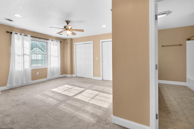 interior space with light carpet, a textured ceiling, and ceiling fan