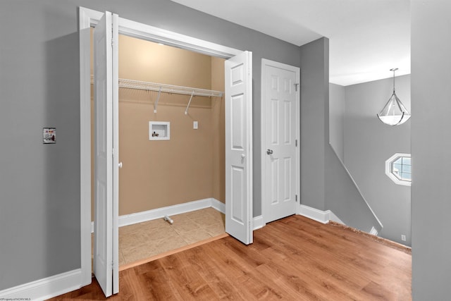 clothes washing area featuring wood-type flooring and hookup for a washing machine