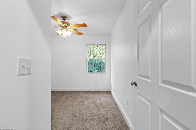 carpeted spare room featuring ceiling fan