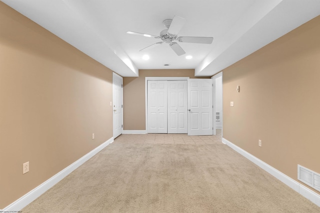 unfurnished bedroom featuring ceiling fan, light colored carpet, and a closet