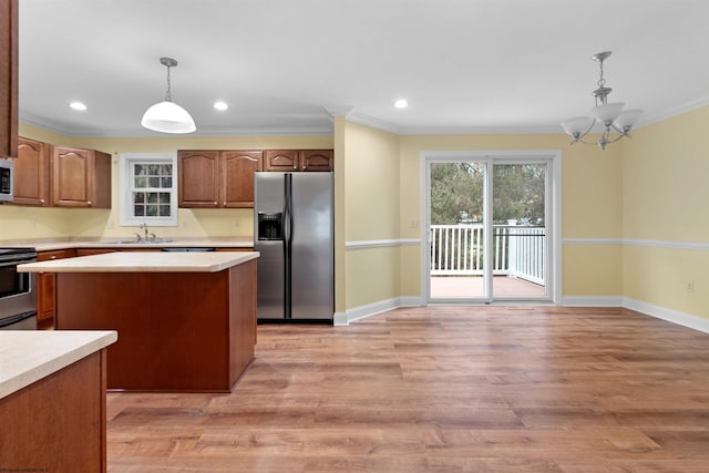 kitchen featuring a chandelier, stainless steel appliances, hanging light fixtures, and light hardwood / wood-style flooring