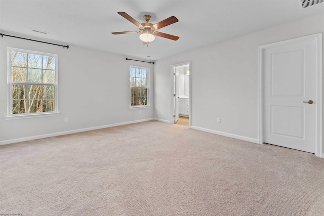 unfurnished room with light carpet, a wealth of natural light, and ceiling fan