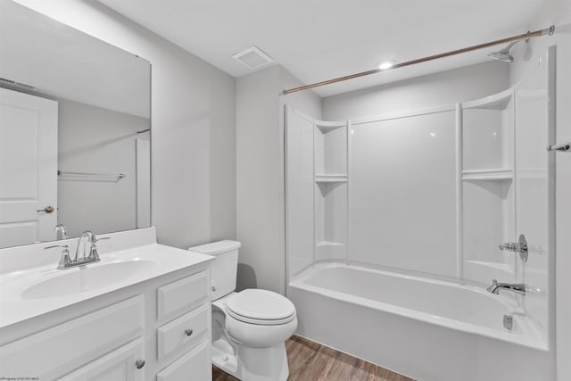 full bathroom featuring washtub / shower combination, toilet, wood-type flooring, and vanity