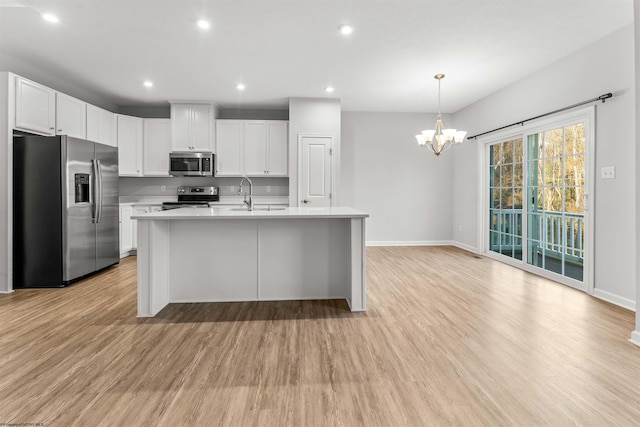 kitchen featuring stainless steel appliances, an inviting chandelier, light hardwood / wood-style flooring, white cabinetry, and hanging light fixtures