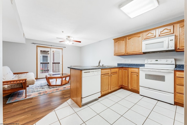 kitchen featuring kitchen peninsula, white appliances, ceiling fan, sink, and light hardwood / wood-style floors