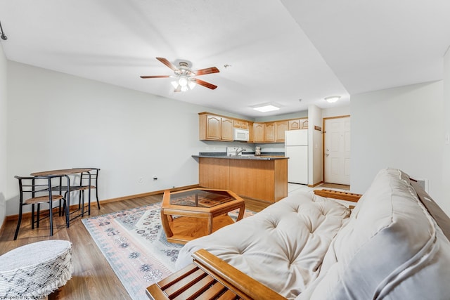 living room featuring ceiling fan, light wood-type flooring, and sink