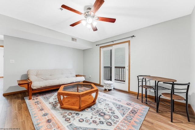 living room with ceiling fan and light hardwood / wood-style flooring